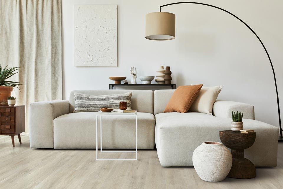 laminate flooring in living room with cream couch and lighting.